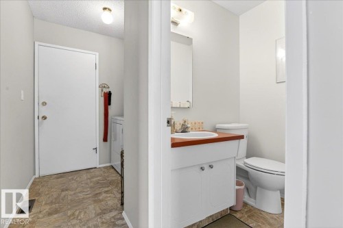 The property features a utility area with a white door, a washing machine, and patterned flooring - 391 Lee Ridge Road, Edmonton, AB - Indoor Photo Showing Bathroom