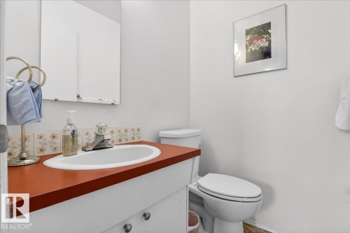 Bathroom featuring a white vanity with a reddish-brown countertop, a white toilet, and a wall-mounted mirror - 391 Lee Ridge Road, Edmonton, AB - Indoor Photo Showing Bathroom