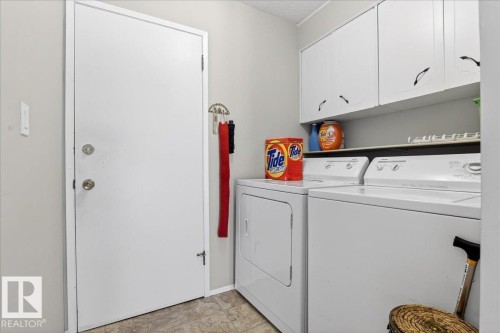 Utility room featuring a washer and dryer, white cabinetry, and a door with knob and deadbolt - 391 Lee Ridge Road, Edmonton, AB - Indoor Photo Showing Laundry Room