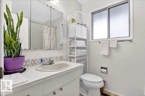 The bathroom features a vanity with an integrated sink, a mirrored medicine cabinet, a window with privacy glass, and a toilet - 391 Lee Ridge Road, Edmonton, AB - Indoor Photo Showing Bathroom