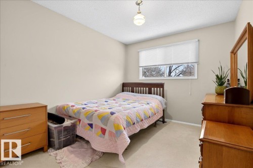 The room features neutral-toned walls and carpeting, a window with blinds, and a ceiling light fixture - 391 Lee Ridge Road, Edmonton, AB - Indoor Photo Showing Bedroom