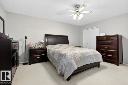 This bedroom features light-colored carpeting, a ceiling fan with integrated lighting, and white bi-fold closet doors - 391 Lee Ridge Road, Edmonton, AB - Indoor Photo Showing Bedroom