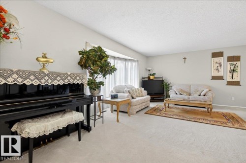 Spacious living area featuring light-colored carpeting, white walls, and a large bay window with vertical blinds - 391 Lee Ridge Road, Edmonton, AB - Indoor Photo Showing Living Room