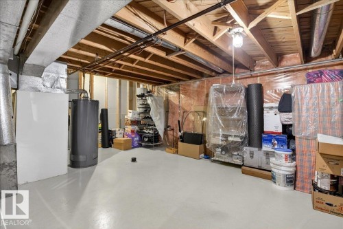 The property features an unfinished basement with exposed wooden joists and ductwork, a water heater, and a white painted floor - 391 Lee Ridge Road, Edmonton, AB - Indoor Photo Showing Basement