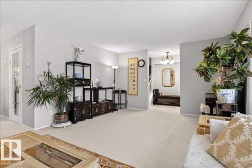The spacious reception area features light-colored carpeting, light gray walls, and white baseboards - 391 Lee Ridge Road, Edmonton, AB - Indoor