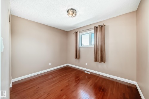 Room featuring rich hardwood floors, a window with curtains, and a ceiling light fixture - 287 Lago Lindo Crescent, Edmonton, AB - Indoor Photo Showing Other Room