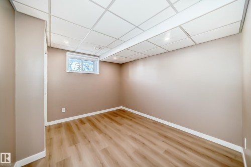 This room features light wood-look flooring, neutral wall paint, and a window providing natural light - 287 Lago Lindo Crescent, Edmonton, AB - Indoor Photo Showing Other Room