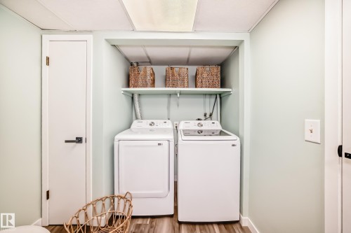 Dedicated laundry area featuring a washer and dryer, a storage shelf, and a light-colored wood-look floor - 287 Lago Lindo Crescent, Edmonton, AB - Indoor Photo Showing Laundry Room