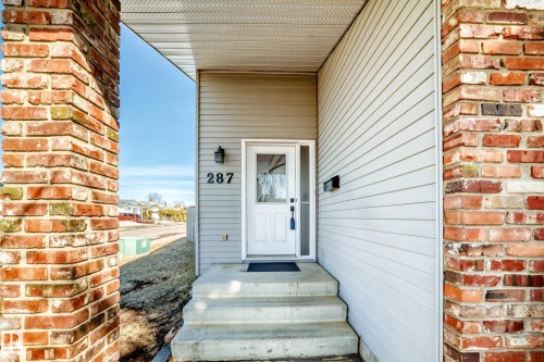 The property features a welcoming entrance with concrete steps and a white front door - 287 Lago Lindo Crescent, Edmonton, AB - Outdoor With Exterior