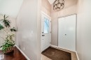 Entryway featuring a white door with decorative glass, a modern light fixture, and a closet with bifold doors - 287 Lago Lindo Crescent, Edmonton, AB  - Indoor Photo Showing Other Room 