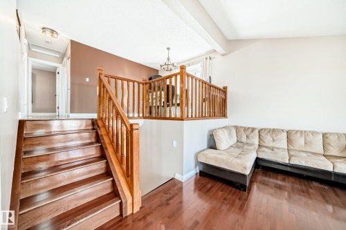 The property features hardwood flooring throughout the main living areas and a wooden staircase - 287 Lago Lindo Crescent, Edmonton, AB - Indoor Photo Showing Living Room