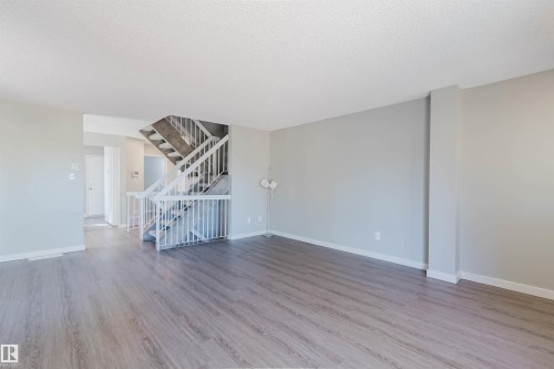 The property features light-colored walls and wood-look flooring throughout, creating an open and airy atmosphere - 17308 61 Avenue, Edmonton, AB - Indoor Photo Showing Other Room