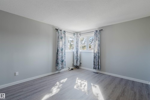 Bright interior space with light gray walls, light flooring, and two windows - 17308 61 Avenue, Edmonton, AB - Indoor