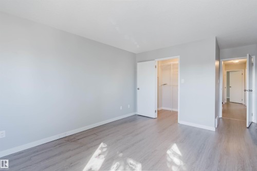 The room features light-toned walls and flooring, an open closet with shelving, and a doorway leading to a hallway - 17308 61 Avenue, Edmonton, AB - Indoor Photo Showing Other Room