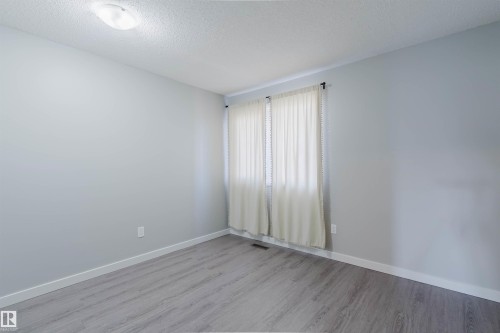 This room features light grey walls, a ceiling light fixture, and a window with white curtains - 17308 61 Avenue, Edmonton, AB - Indoor Photo Showing Other Room