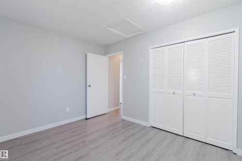 This room features grey wood-look flooring, light grey walls, and white baseboards - 17308 61 Avenue, Edmonton, AB - Indoor Photo Showing Other Room