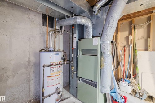 The property includes a water heater and furnace, with exposed ductwork and concrete walls - 17308 61 Avenue, Edmonton, AB - Indoor Photo Showing Basement