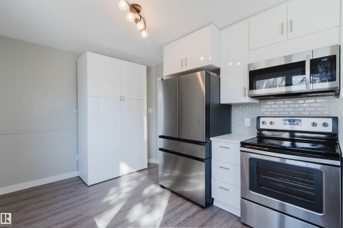 The kitchen features stainless steel appliances, including a refrigerator, microwave, and range - 17308 61 Avenue, Edmonton, AB - Indoor Photo Showing Kitchen With Stainless Steel Kitchen