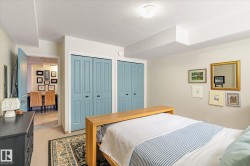 This room features neutral-toned walls, two sets of bi-fold closet doors, and a carpeted floor with an area rug - 