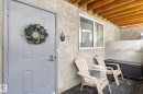 The property features an outdoor patio area with a textured wall, exposed wooden ceiling beams, and a sliding window - 5 4902B 43 Street, Legal, AB 