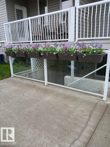 Ground-level patio with concrete surfacing and a glass-paneled barrier - 5 4902B 43 Street, Legal, AB 