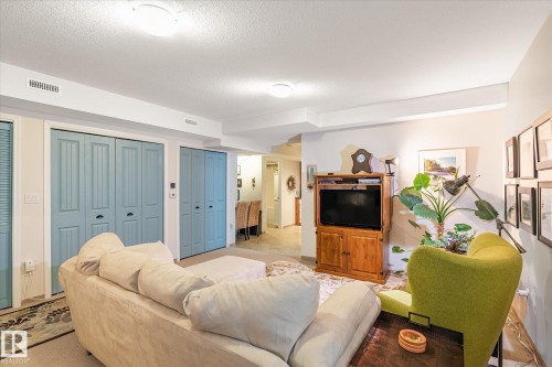 The living area features light-colored walls and two light blue bi-fold doors - 5 4902B 43 Street, Legal, AB 
