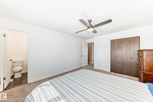 Bedroom with a ceiling fan, carpeted flooring, and a wardrobe with four dark wood doors - 11323 162 Avenue, Edmonton, AB - Indoor Photo Showing Bedroom