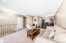 Inviting living area featuring light-colored carpeting, a rustic wood coffee table, and a dining area with hardwood flooring - 11323 162 Avenue, Edmonton, AB  - Indoor Photo Showing Living Room 