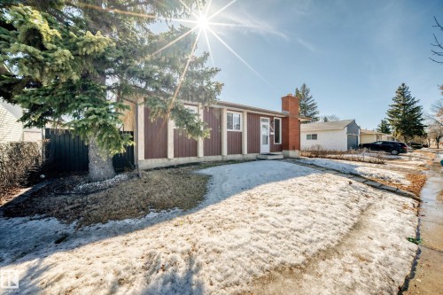 The property features a brown exterior with white trim and a prominent brick chimney - 11323 162 Avenue, Edmonton, AB - Outdoor