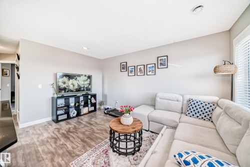 Living area featuring light-colored walls, recessed lighting, and wood-style flooring - 11 1530 Tamarack Boulevard, Edmonton, AB - Indoor Photo Showing Living Room