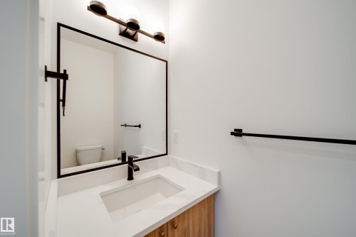 Bathroom vanity featuring a rectangular undermount sink, a white countertop, and a black faucet - 9536 148 Street, Edmonton, AB - Indoor Photo Showing Bathroom