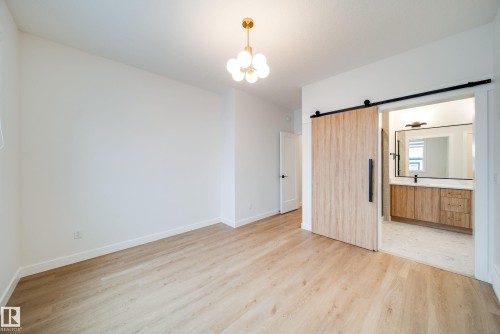 This room features light wood-look flooring and white walls, creating a bright and airy atmosphere - 9536 148 Street, Edmonton, AB - Indoor Photo Showing Other Room
