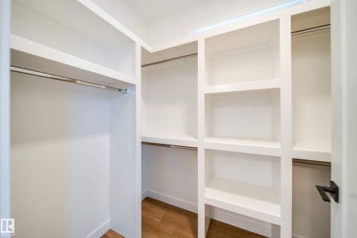 Well-appointed closet featuring built-in shelving, hanging rods, and hardwood flooring - 9536 148 Street, Edmonton, AB - Indoor With Storage