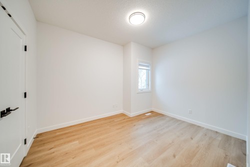 This inviting room features light wood-look flooring and a window, providing natural light - 9536 148 Street, Edmonton, AB - Indoor Photo Showing Other Room