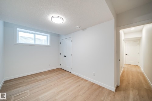 This bright room features light wood flooring, white walls, and a window with blinds - 9536 148 Street, Edmonton, AB - Indoor Photo Showing Other Room