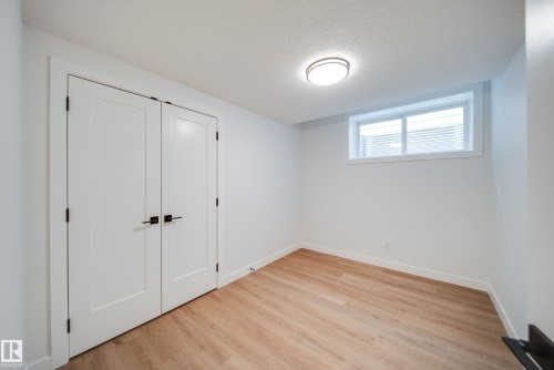 This room features light wood-style flooring, white walls, and a window with blinds - 9536 148 Street, Edmonton, AB - Indoor Photo Showing Other Room