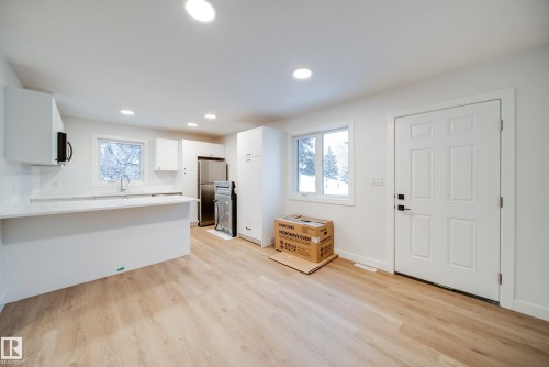 This bright and open-concept space features light-toned flooring, white walls, and recessed lighting - 9536 148 Street, Edmonton, AB - Indoor