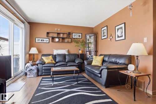 The living space features light wood flooring and a large sliding glass door - 3237 142 Avenue, Edmonton, AB - Indoor Photo Showing Living Room
