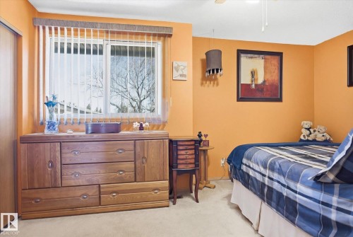 The room features a window with vertical blinds, providing adjustable natural light - 3237 142 Avenue, Edmonton, AB - Indoor Photo Showing Bedroom