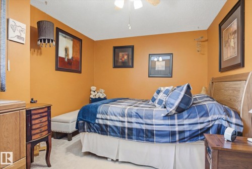 This bedroom features neutral-toned carpeting, warm-toned walls, and a ceiling fan - 3237 142 Avenue, Edmonton, AB - Indoor Photo Showing Bedroom