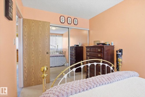 This room features a sliding mirrored closet door and carpeted flooring - 3237 142 Avenue, Edmonton, AB - Indoor Photo Showing Bedroom