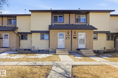 The property features an exterior with light brown stucco and beige siding, complemented by dark trim - 3237 142 Avenue, Edmonton, AB - Outdoor With Facade