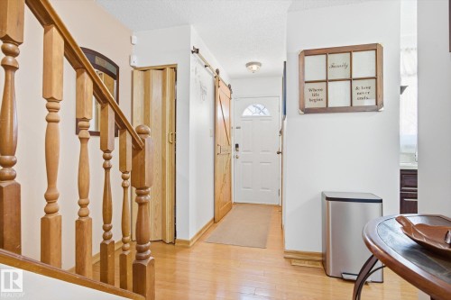 The interior features hardwood flooring and a white front entry door with a decorative window - 3237 142 Avenue, Edmonton, AB - Indoor Photo Showing Other Room