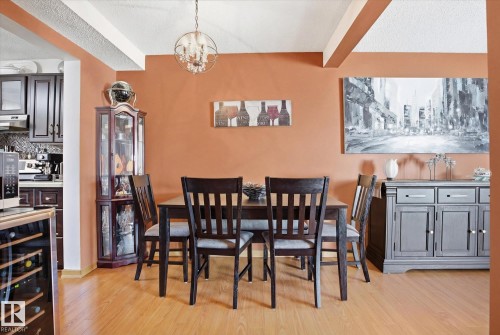 The dining area features light-toned flooring, a chandelier, and a decorative wall color - 3237 142 Avenue, Edmonton, AB - Indoor Photo Showing Dining Room