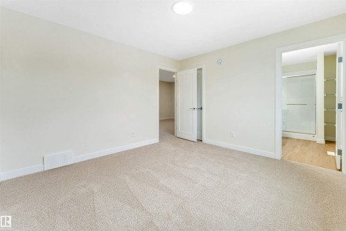 Spacious room featuring neutral carpet flooring, a ceiling-mounted light fixture, and white trim - 91 Dansereau Way, Beaumont, AB - Indoor Photo Showing Other Room