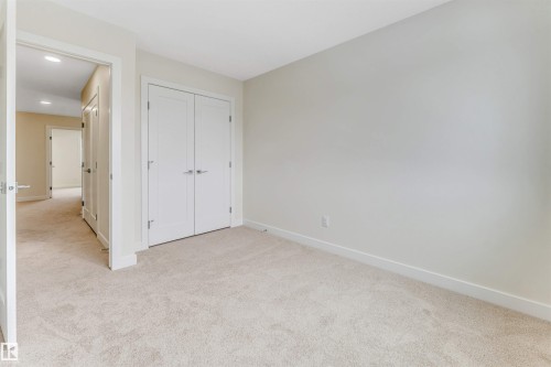 This room features neutral-toned carpet flooring and light-colored walls, creating a versatile aesthetic - 91 Dansereau Way, Beaumont, AB - Indoor Photo Showing Other Room