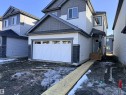 The property features a two-story exterior with light-colored siding and dark grey trim accents - 91 Dansereau Way, Beaumont, AB  - Outdoor 