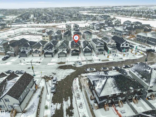 Aerial view highlighting the property within a residential neighborhood featuring detached and attached homes, paved streets, and surrounding open areas - 91 Dansereau Way, Beaumont, AB - Outdoor With View