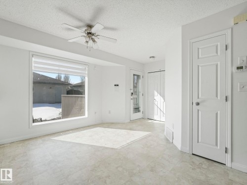 Bright living space featuring a large window, a ceiling fan, and light-colored flooring - 675 Mcallister Loop, Edmonton, AB - Indoor Photo Showing Other Room