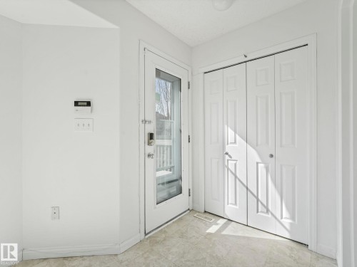 Entryway with light-colored flooring, a glass-paneled door, and bi-fold doors - 675 Mcallister Loop, Edmonton, AB - Indoor Photo Showing Other Room